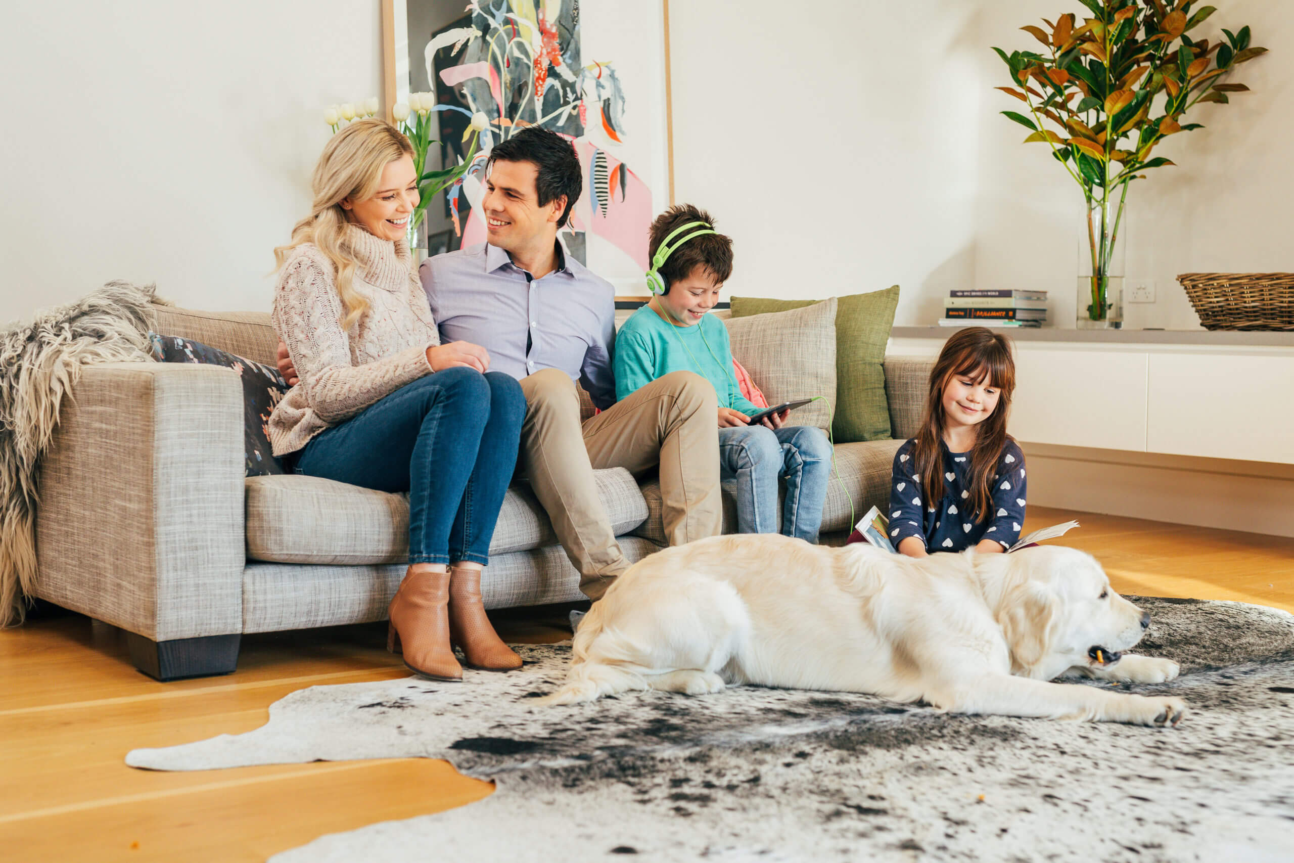 A family of four with their dog enjoying their beautifully clean home