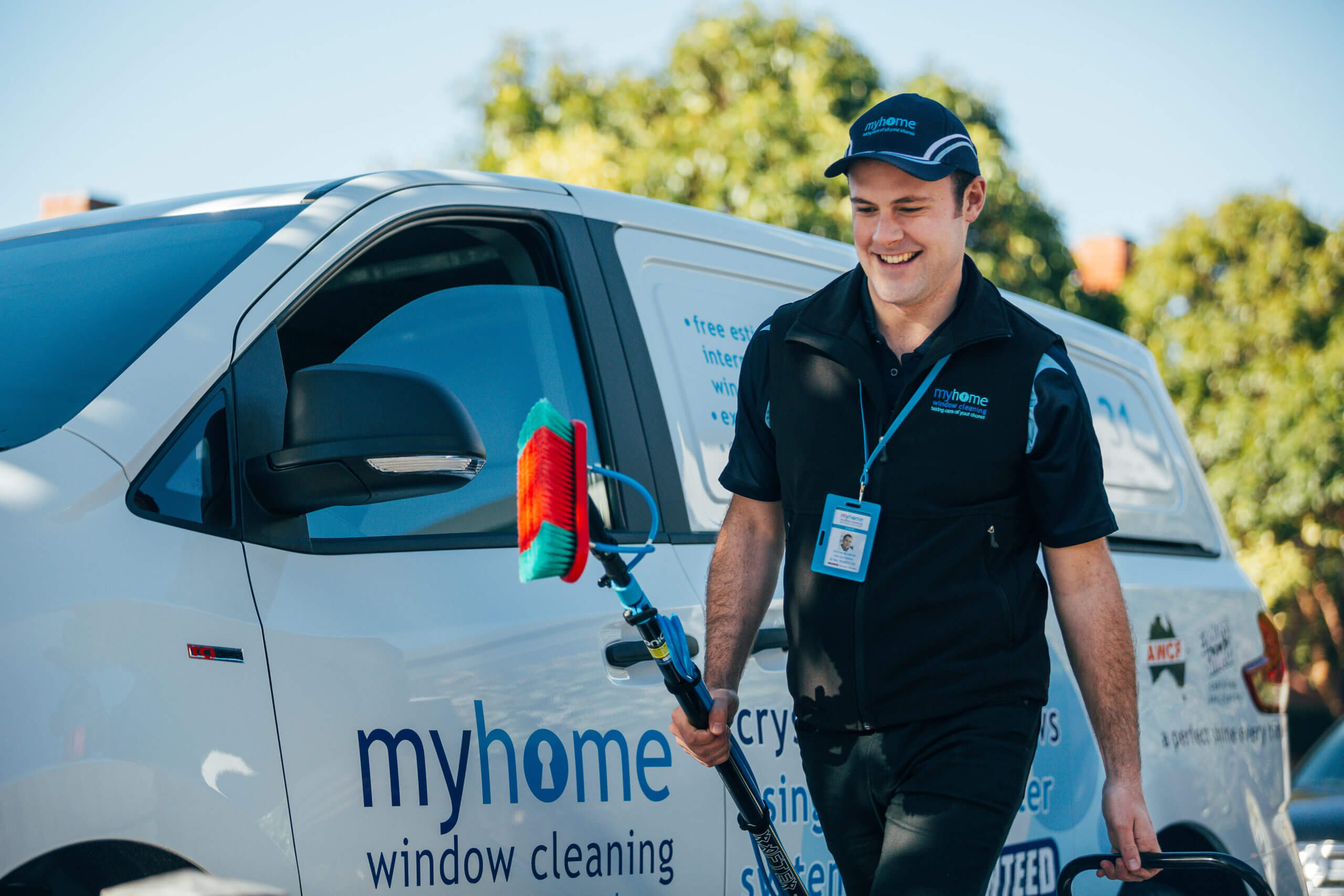 A MyHome window cleaner walking away from his van with UltraPure window cleaning equipment